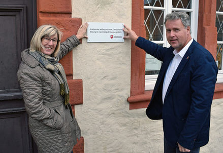 Die Wissenschaftliche Mitarbeiterin Christine Kellner-Depner (links) und der Kulturdezernent der Stadt Salzgitter, Jan Erik Bohling, brachten das Schild außerschulischer Lernort am Museum an.