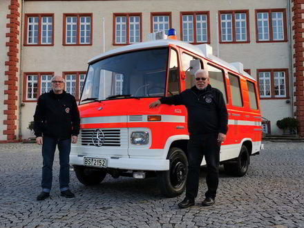 Der Infektionstransportwagen vor dem Städtischen Museum Schloss Salder mit den beiden Überbringern Ralf Wiese (links), Hans-Ludwig Sämann (rechts) vom Förderverein Feuerwehr und Jugendfeuerwehr Braunschweig e. V.