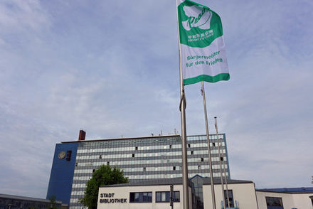 Flagge "Bürgermeister für den Frieden" weht vor dem Rathaus.