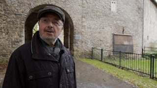 Ortsheimatpfleger Reinhard Försterling, rechts von ihm die verbarrikadierte Fensteröffnung.